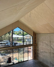 Modern room in Shed House with large glass window overlooking a residential area