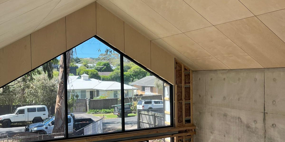 Modern room in Shed House with large glass window overlooking a residential area