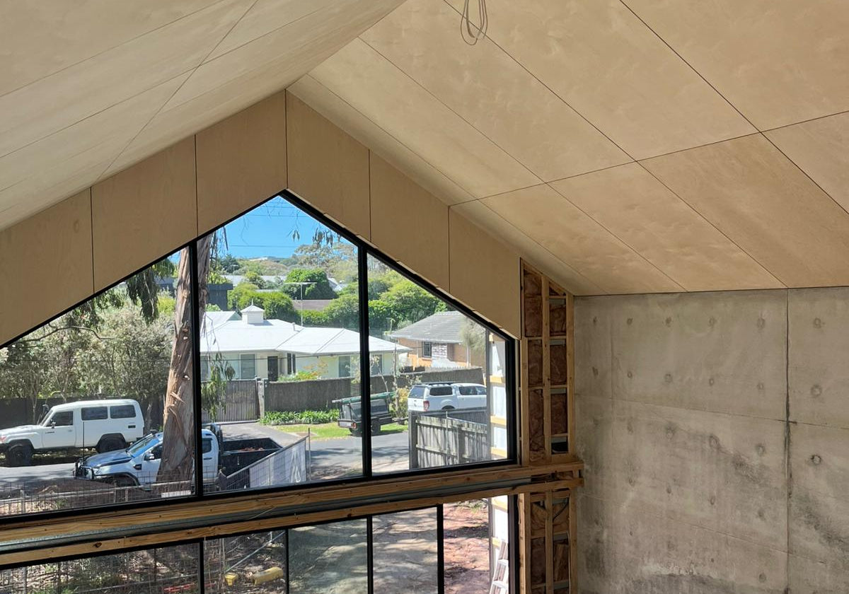 Modern room in Shed House with large glass window overlooking a residential area